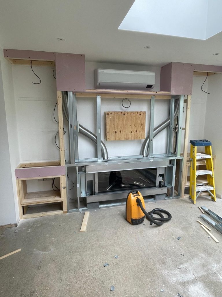 Framework stage of a bespoke media wall showing non-combustible metal studwork and cement board installation in Chatteris, Cambridgeshire.