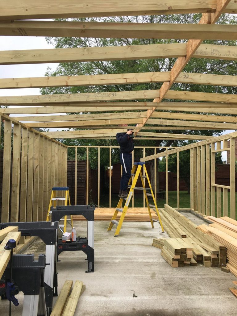 Timber frame structure under construction for a bespoke garage joinery project.