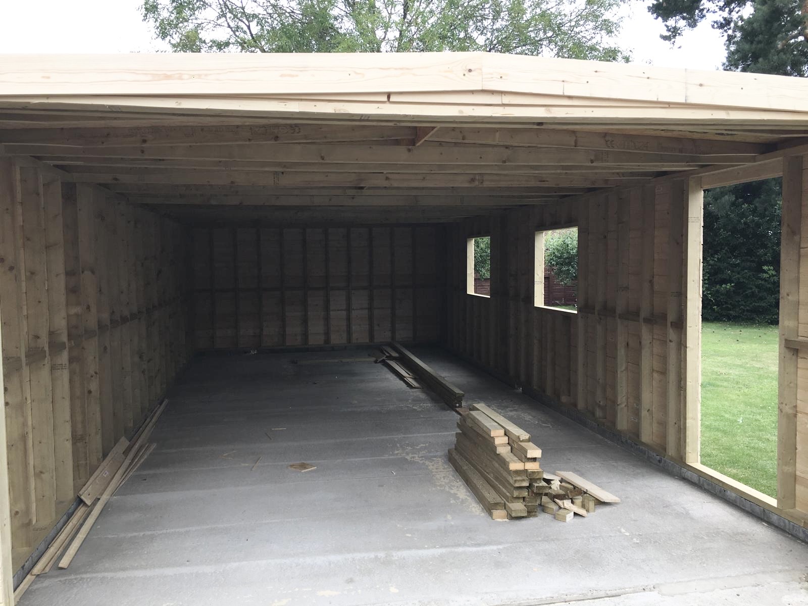Inside view of timber garage showing pressure treated studwork and open internal structure before finishing.