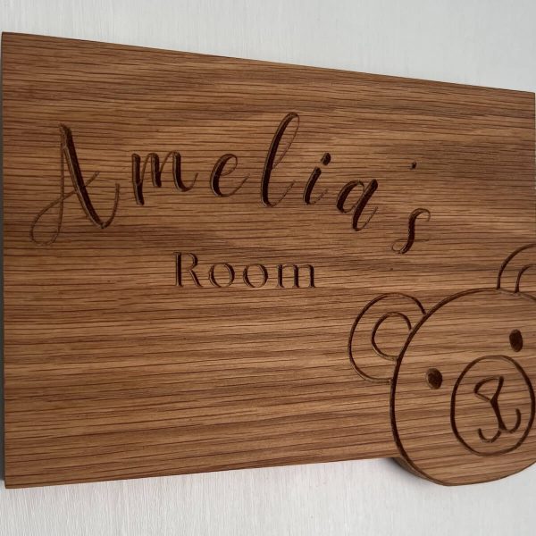 Handmade oak children’s room sign engraved with name and teddy bear detail, wall mounted.