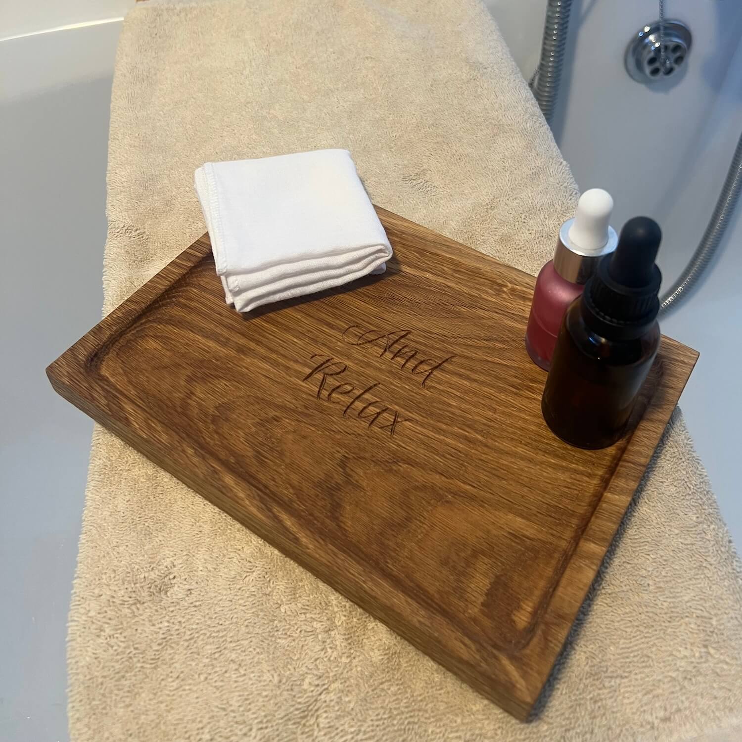 Engraved oak storage tray shown with folded cloth and skincare accessories.
