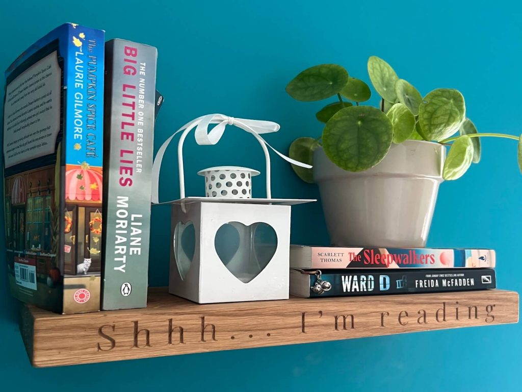 Oak floating shelf with “Shhh… I’m reading” engraving, styled with books and a plant.