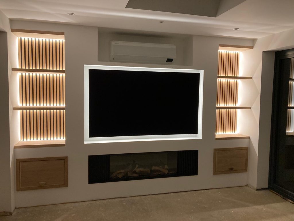 Completed media wall in Cambridgeshire with oak detailing, integrated fireplace and LED lights.