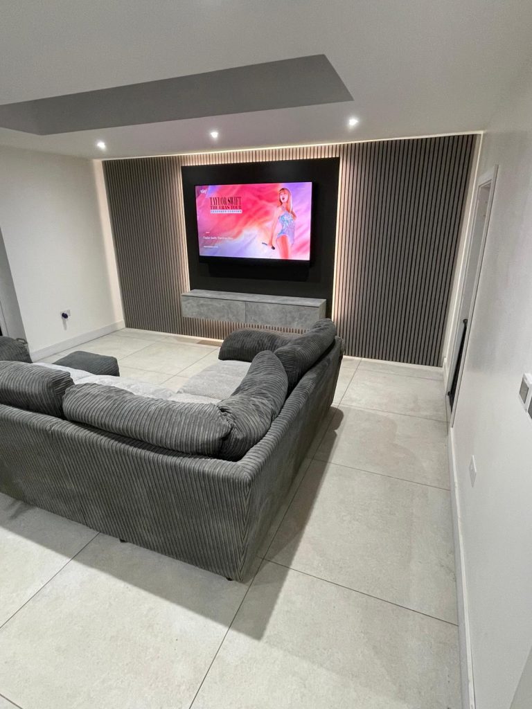 Media wall with vertical slatted panels recessed TV and lighting Cambridgeshire.