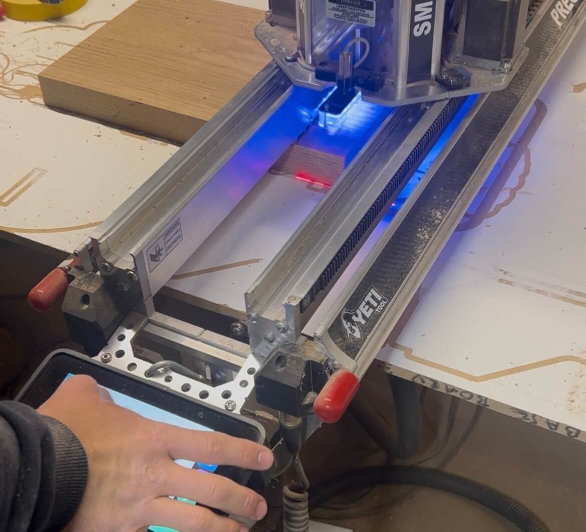 CNC router cutting timber components during batch production process in joinery workshop.