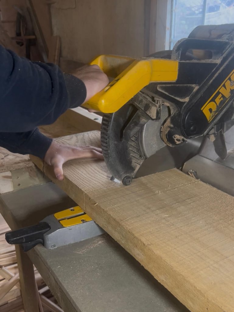 A craftsman cutting a thick slab of FSC-certified white oak, the first step in making a personalised solid oak chopping board.