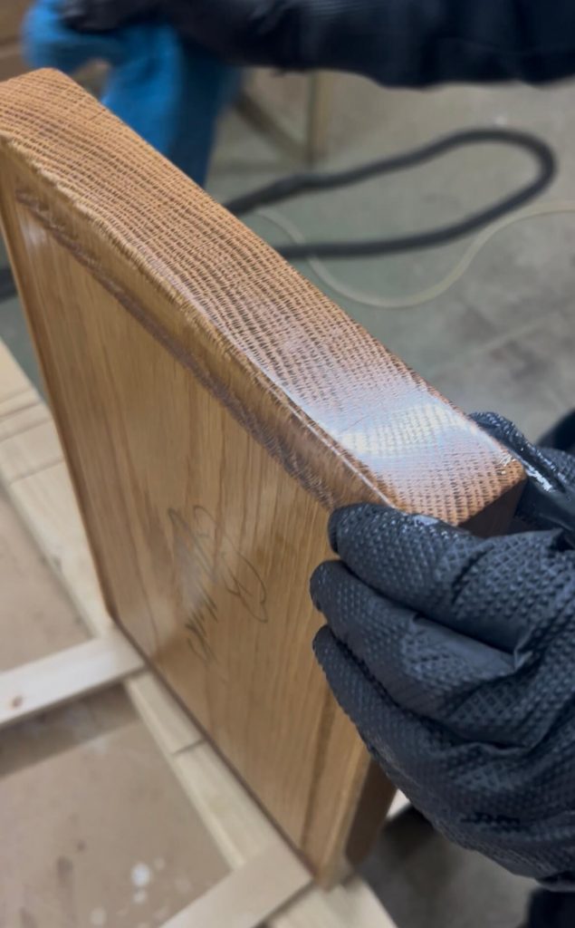 Close-up of a handcrafted oak chopping board being finished with food-safe oil to enhance the grain and protect the wood.