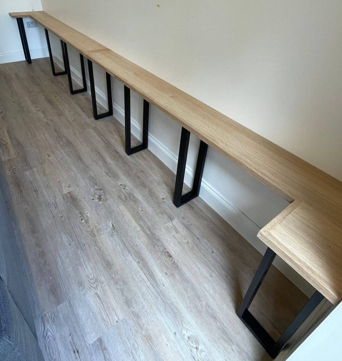 Oak console shelf with black legs installed alongside acoustic wall panelling in a Cambridgeshire living room.