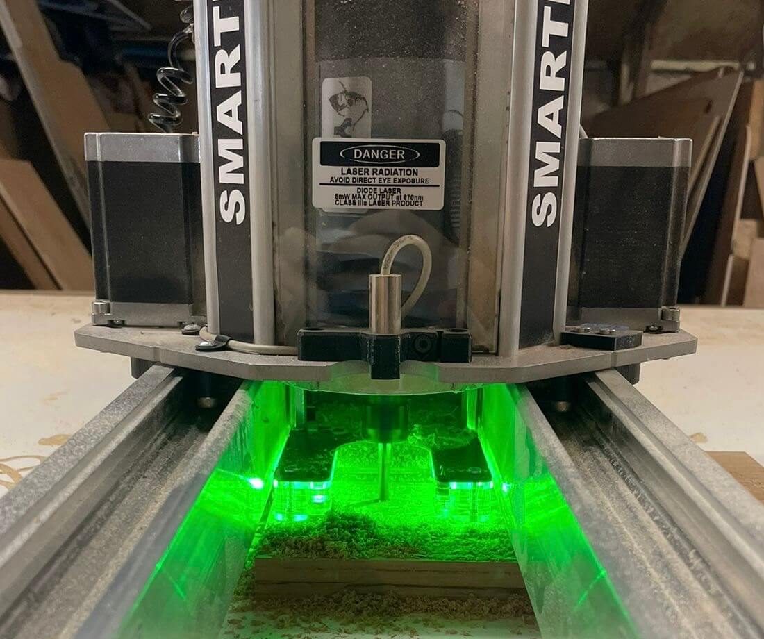 CNC router cutting hardwood timber components in KMP workshop, precision CNC manufacturing in Cambridgeshire.