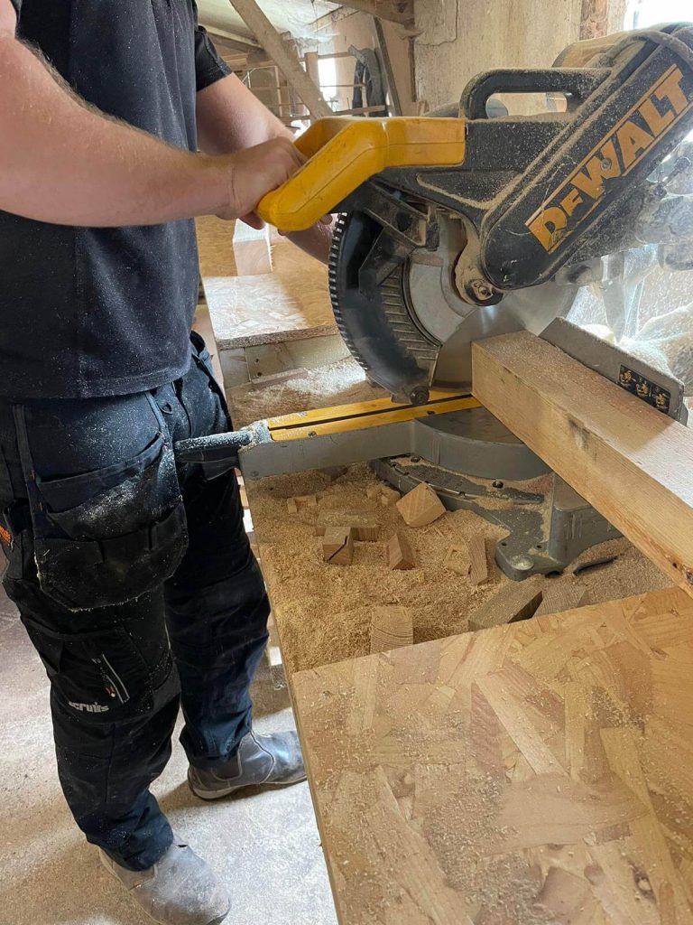 Cutting FSC-certified oak on a mitre saw in the KMP workshop.