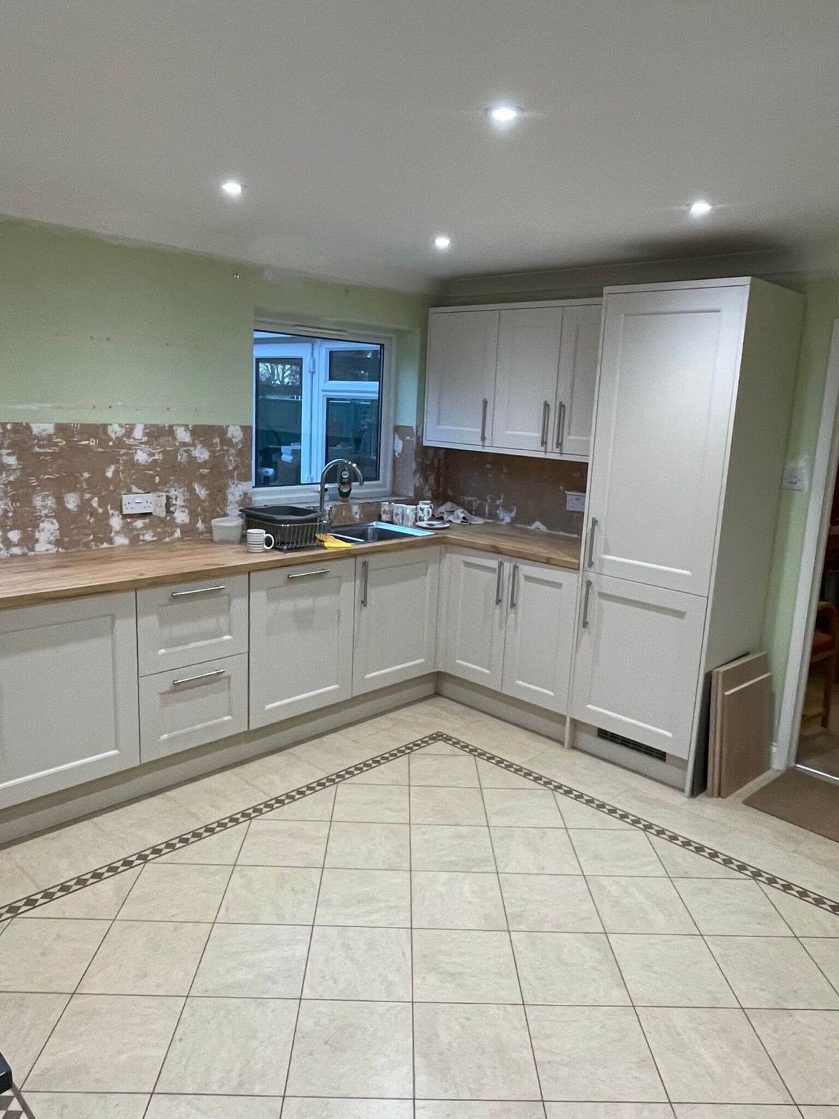Fitted kitchen project in Cambridgeshire with newly installed units and oak laminate worktops, completed by KMP Carpentry & Joinery before adding custom floating shelves.
