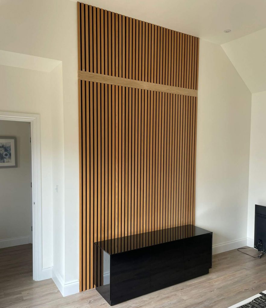 Contemporary oak slatted feature wall with bespoke cabinetry in a Cambridgeshire living space.