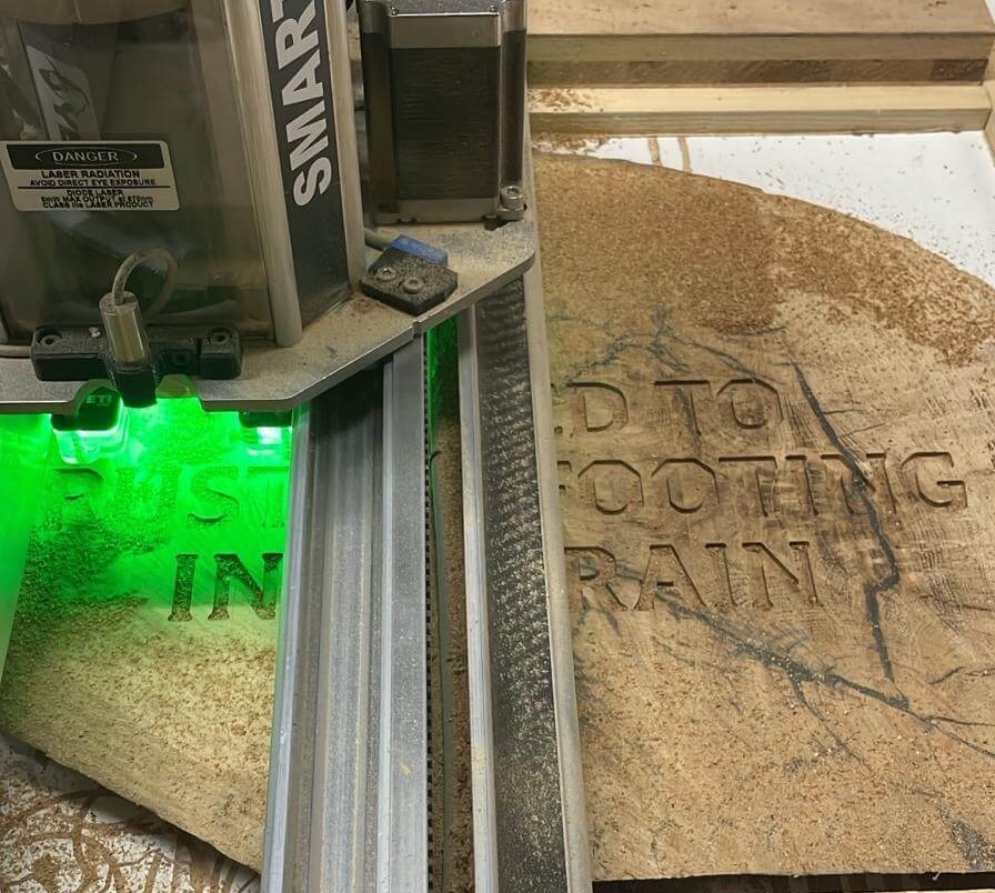CNC engraving detail on solid oak plaque, precision timber component manufacturing.