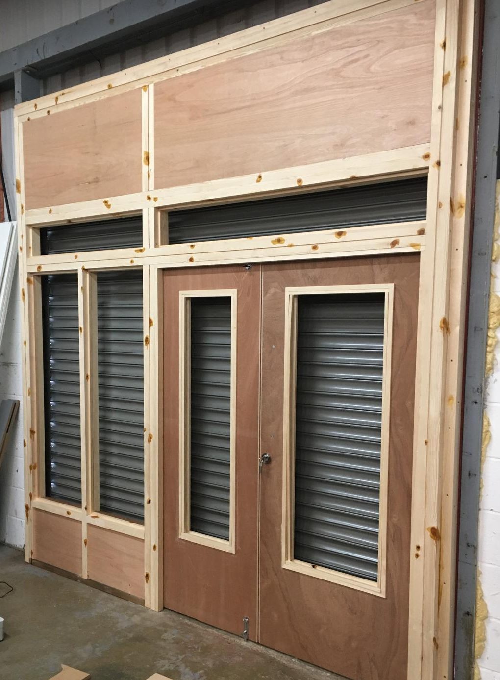 Commercial shop front joinery installation with timber framing and entrance doors.