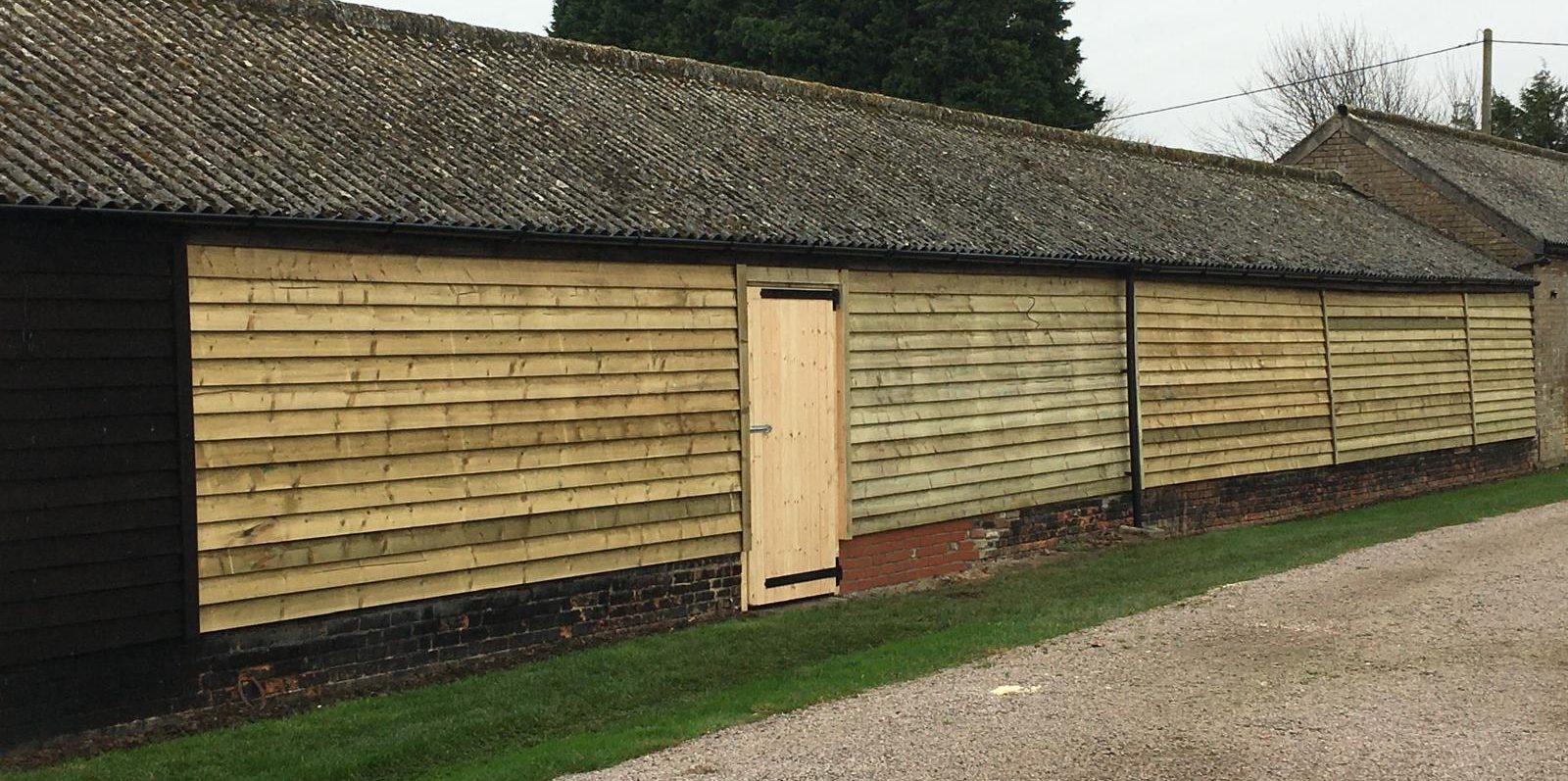 Timber cladding and door installation as part of a commercial stable refurbishment project in Cambridgeshire.