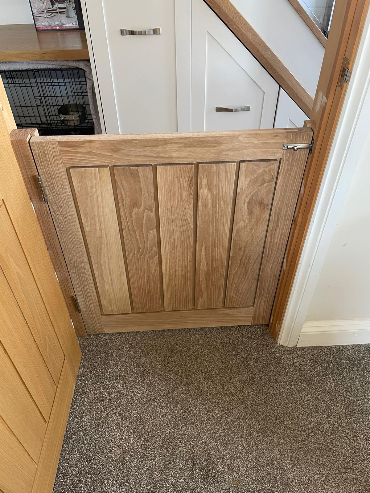 Custom oak dog gate designed to match existing joinery and blend seamlessly into the home.