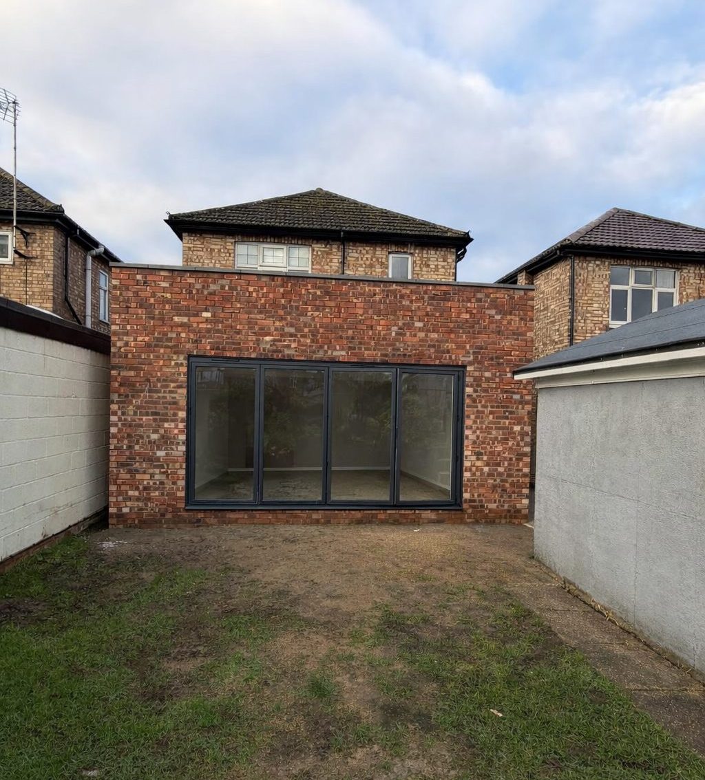 Completed residential brick extension with large glazing installed by main contractor in Cambridgeshire.