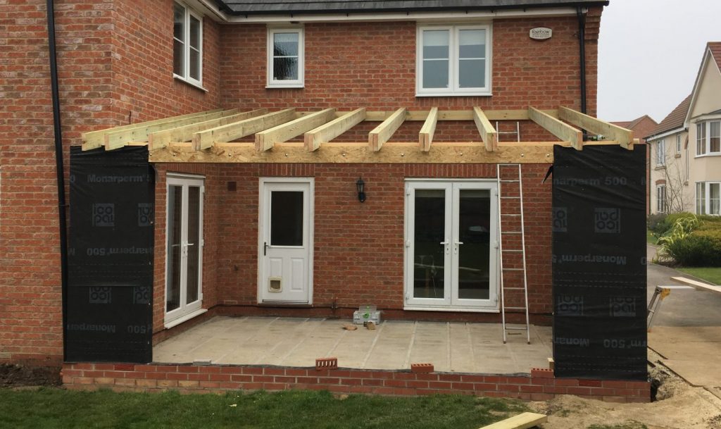 Rear house extension in Cambridgeshire with new structural timber roof framing installed.