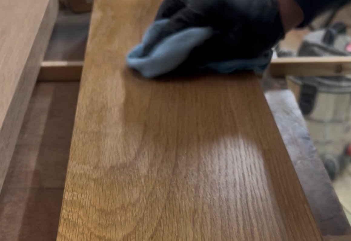 Solid oak timber component being hand-finished after CNC machining in Cambridgeshire workshop.