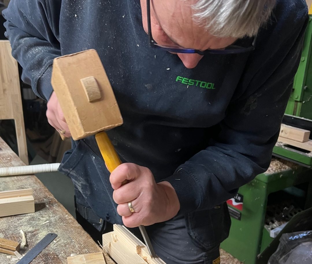 Local carpenter in Cambridgeshire shaping wood in a joinery workshop.