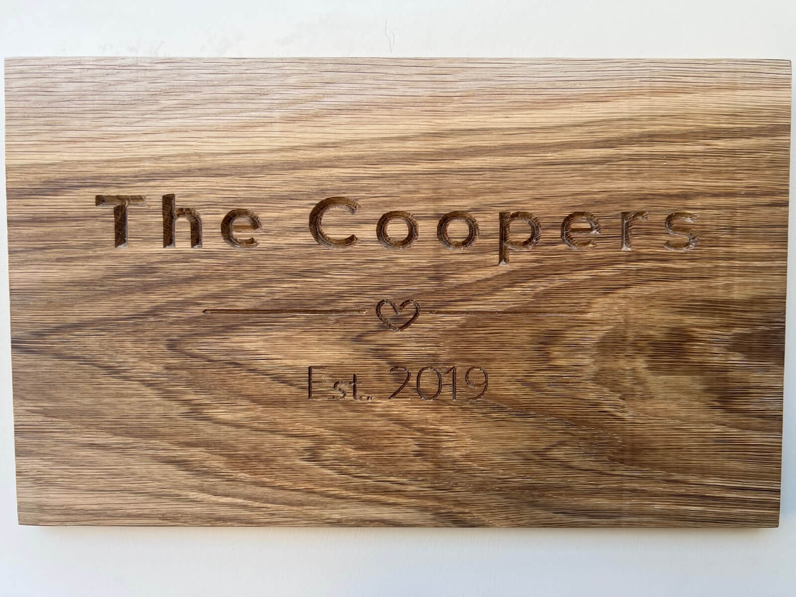 Engraved oak family name plaque with custom text, CNC machined wooden sign.