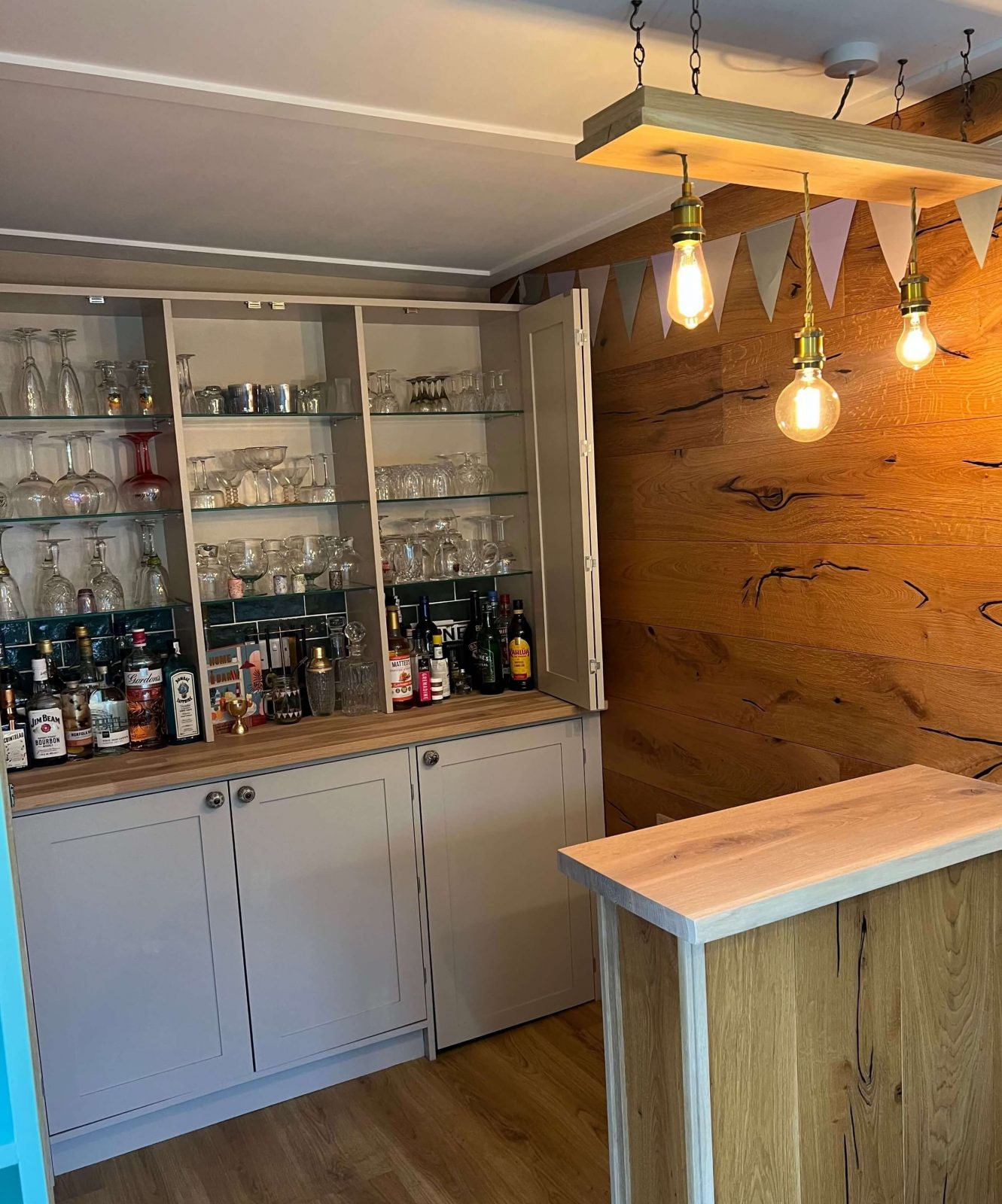 Bespoke drinks cabinet with illuminated shelving in garden room bar build.