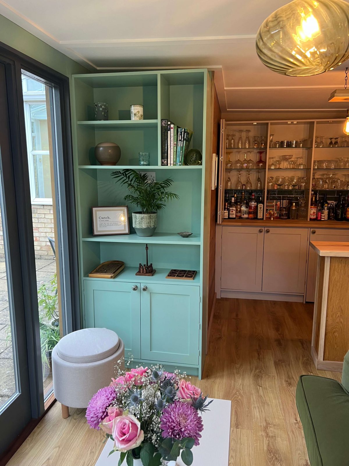 Garden room shelving unit with fitted cupboards and open display shelves.