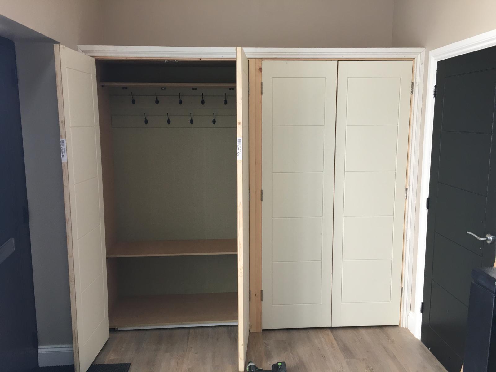 Cloakroom storage open showing hanging rail and internal shelving.