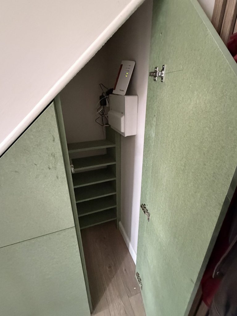 Understairs cupboard with shelving and wifi router storage Cambridgeshire.