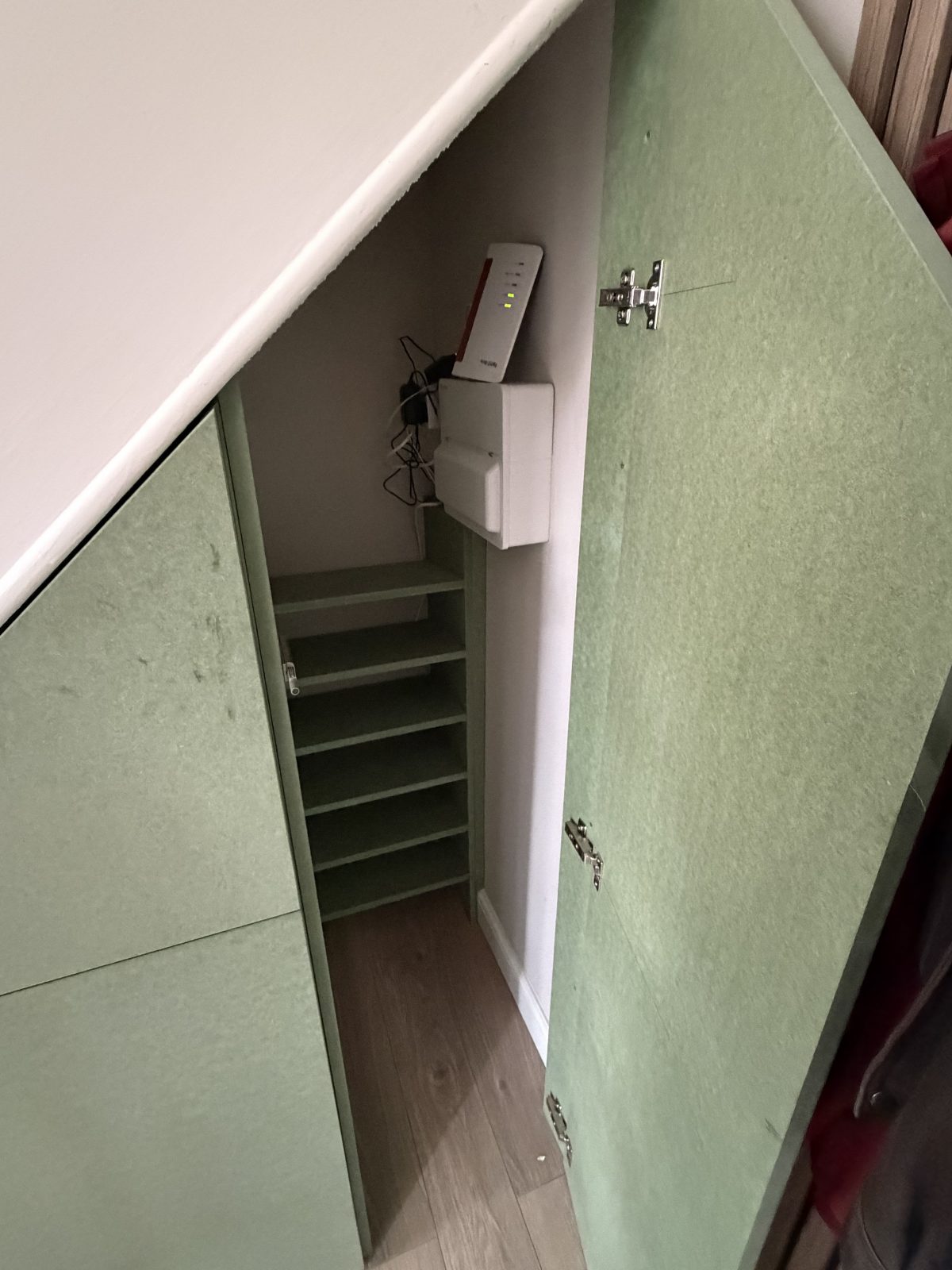 Understairs cupboard with shelving and wifi router storage Cambridgeshire.