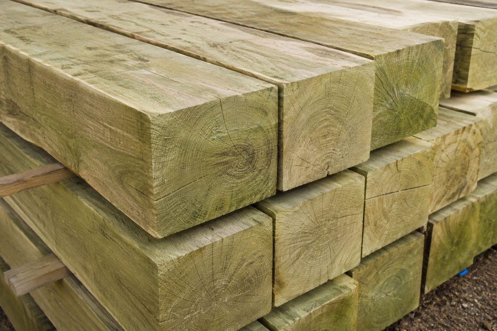 Freshly sawn green oak timber beams showing natural grain and moisture content before use in timber frame construction.