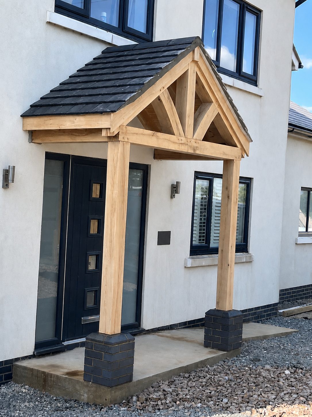 Completed green oak porch built using traditional timber framing techniques at a home in Cambridgeshire.
