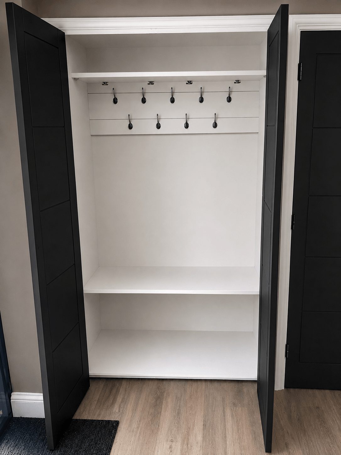 Bespoke fitted cloakroom wardrobe with built-in hanging space and shelving