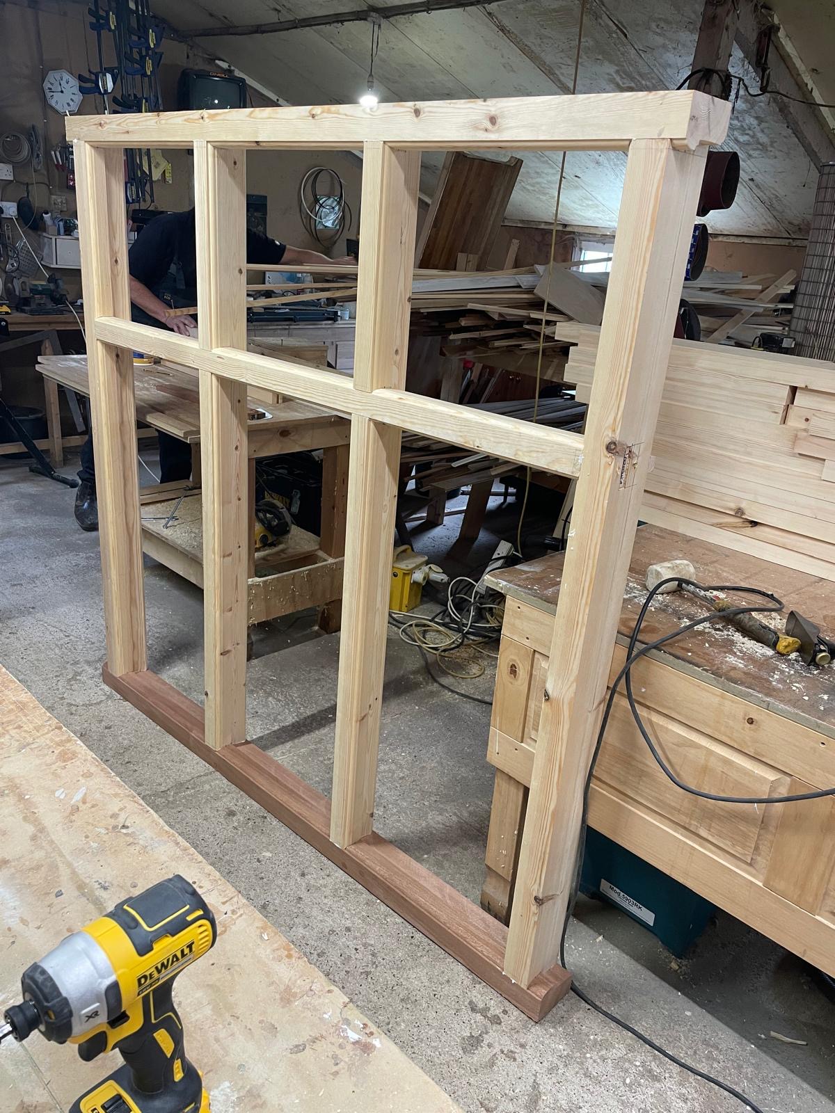 Traditional timber window frame being handcrafted in the workshop using mortise and tenon joinery before installation.